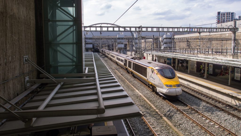 A Eurostar train passing through the concrete jungle of Stratford International station in East London.